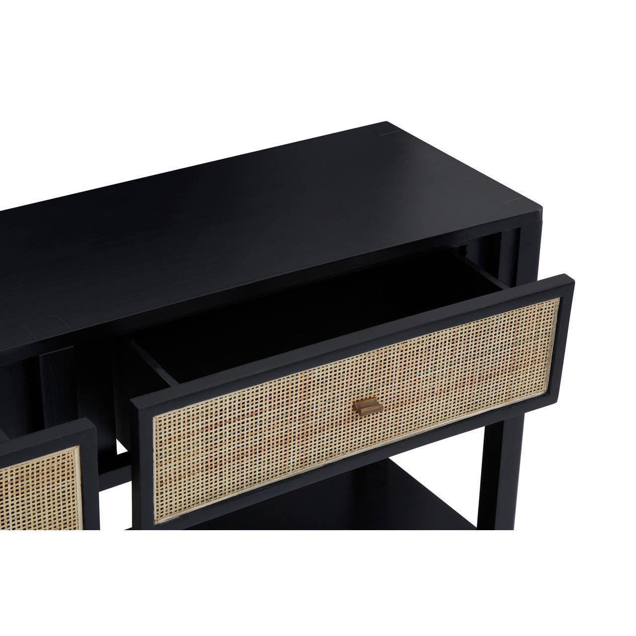 Black console table with rattan drawer front and brass handle, close-up angle