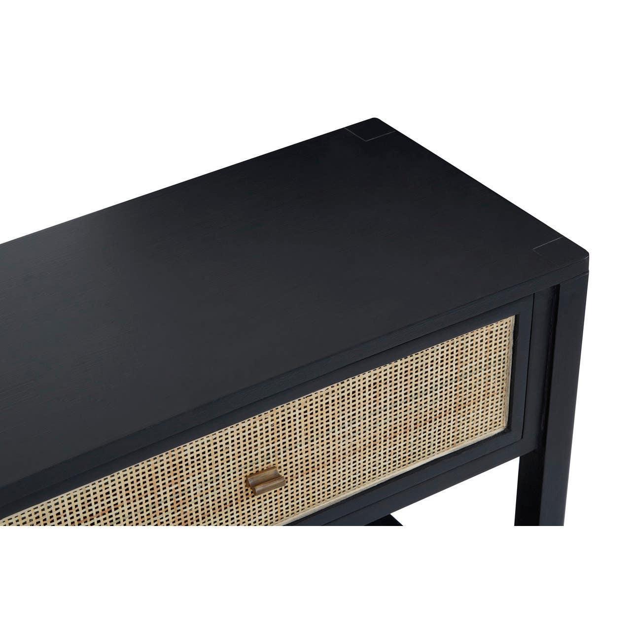 Black console table with natural rattan drawer and brass handle, angled top view