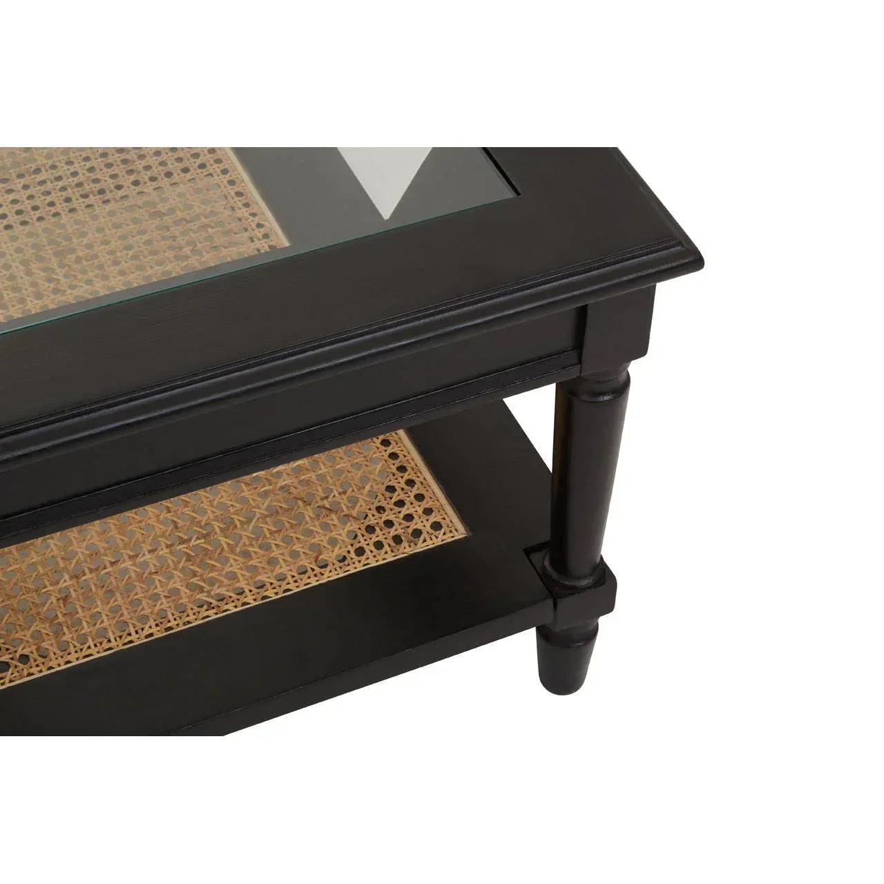Black coffee table with glass top and rattan lower shelf, close up on corner leg