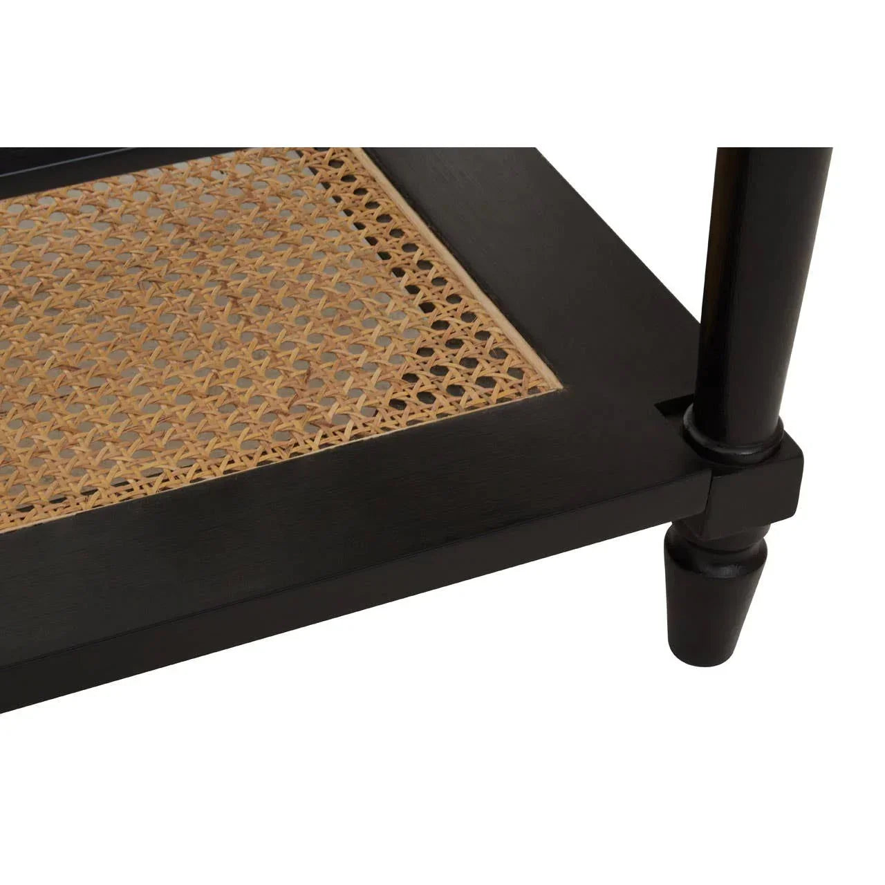 Closeup of black wood table leg and rattan shelf with woven pattern
