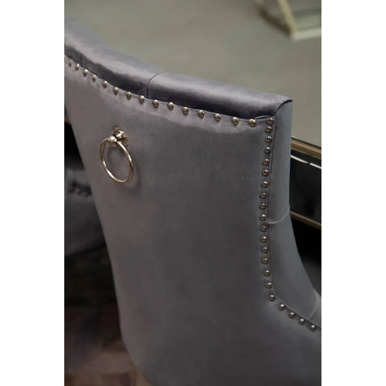 Grey velvet dining chair with silver stud detail and chrome knocker handle