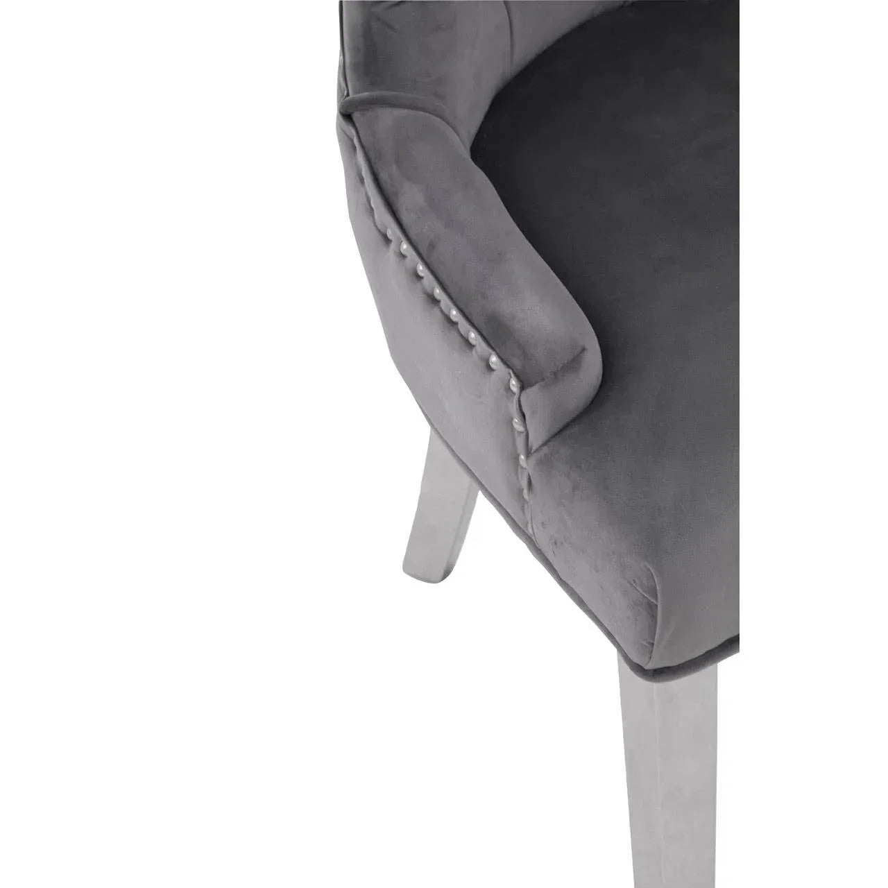 Grey velvet dining chair with silver stud detail and light wooden legs, angled side view