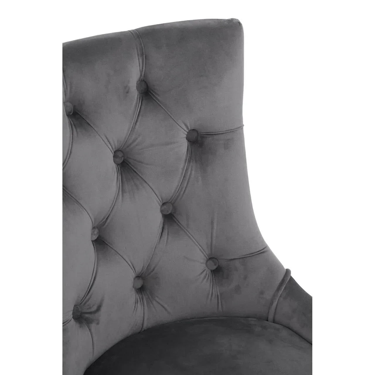 Grey velvet dining chair with deep button-tufted backrest, close-up view