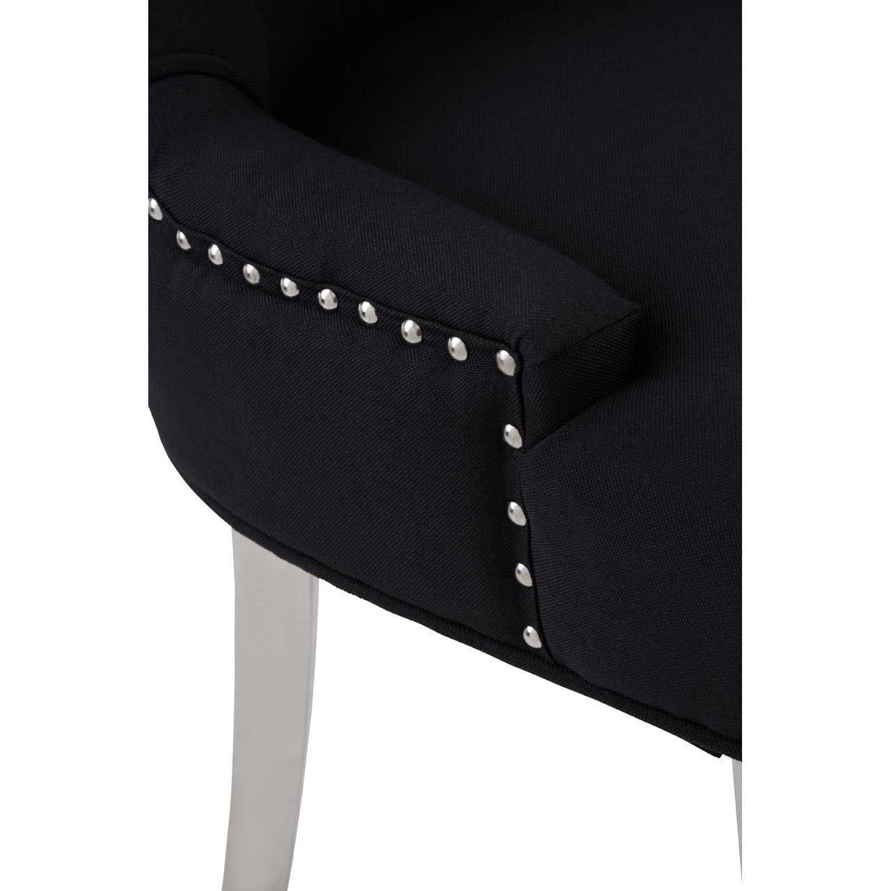 Black upholstered armchair corner with silver stud detailing and light wooden leg