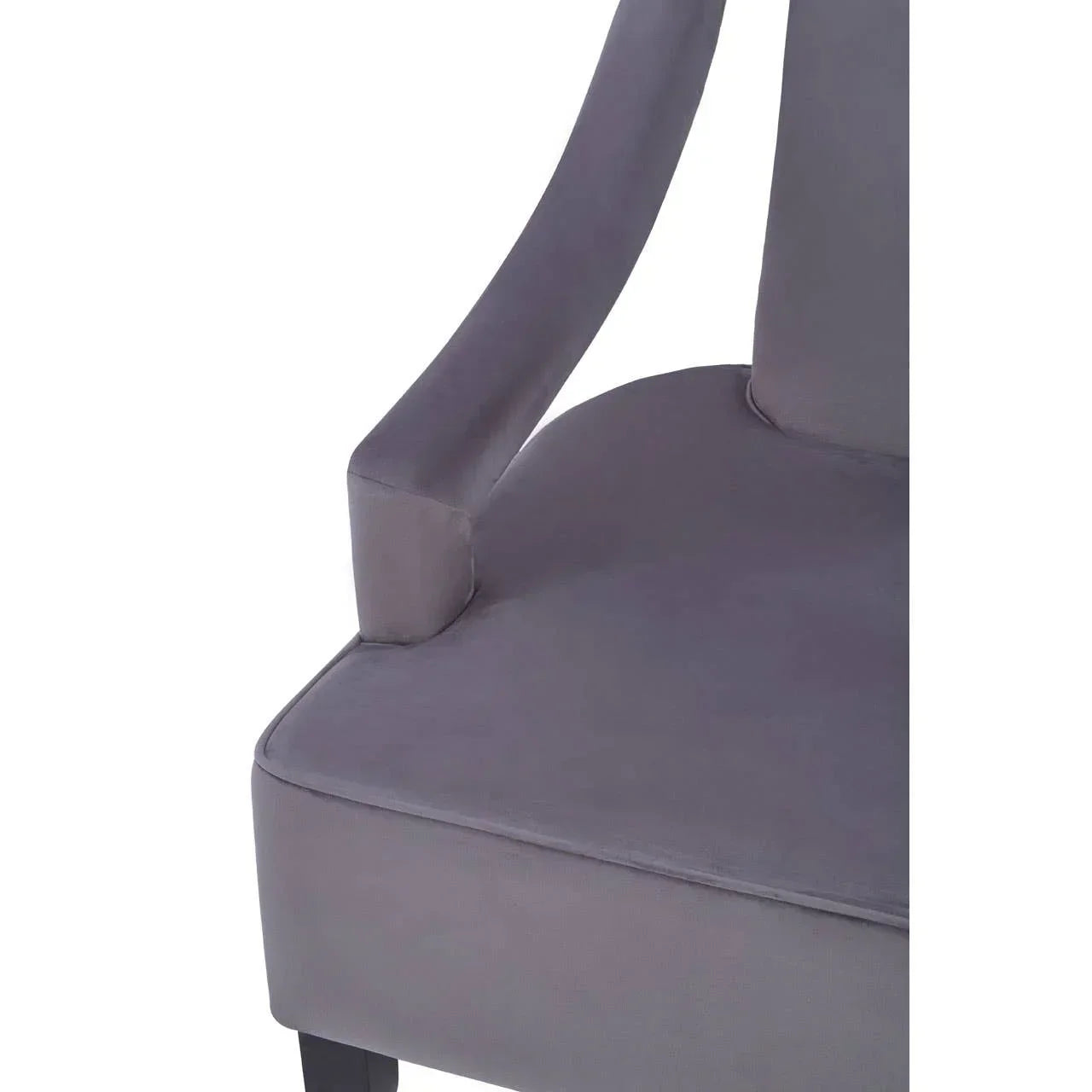Closeup of grey upholstered chair seat with curved armrest and black wooden leg