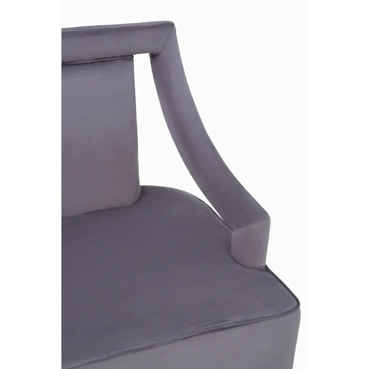 Grey velvet dining chair with curved armrest and padded seat close-up