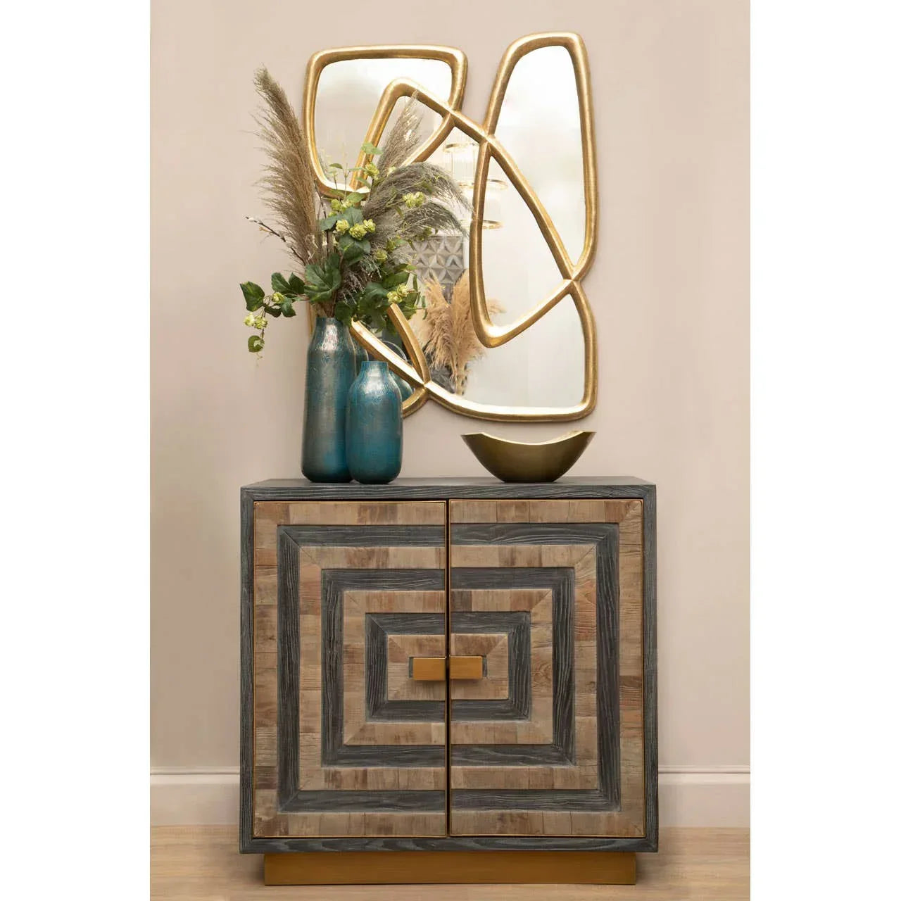 Geometric wood sideboard with gold base, blue vases, and decorative gold wall mirror