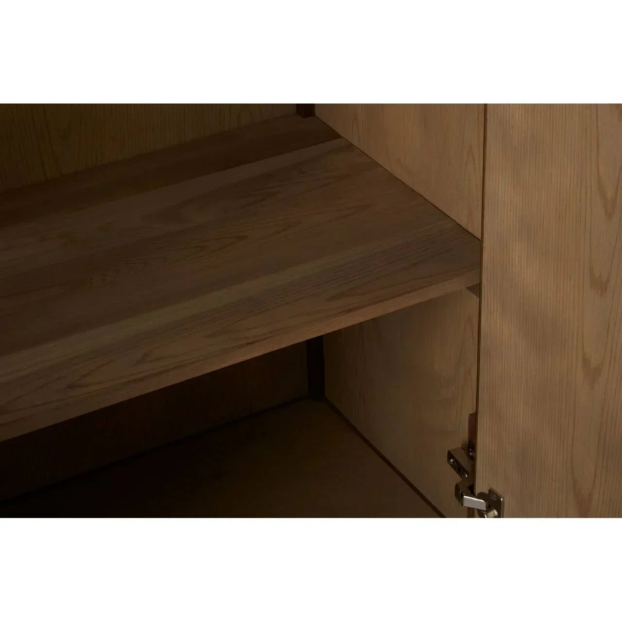 Natural wood cupboard interior with adjustable shelf and metal hinge detail