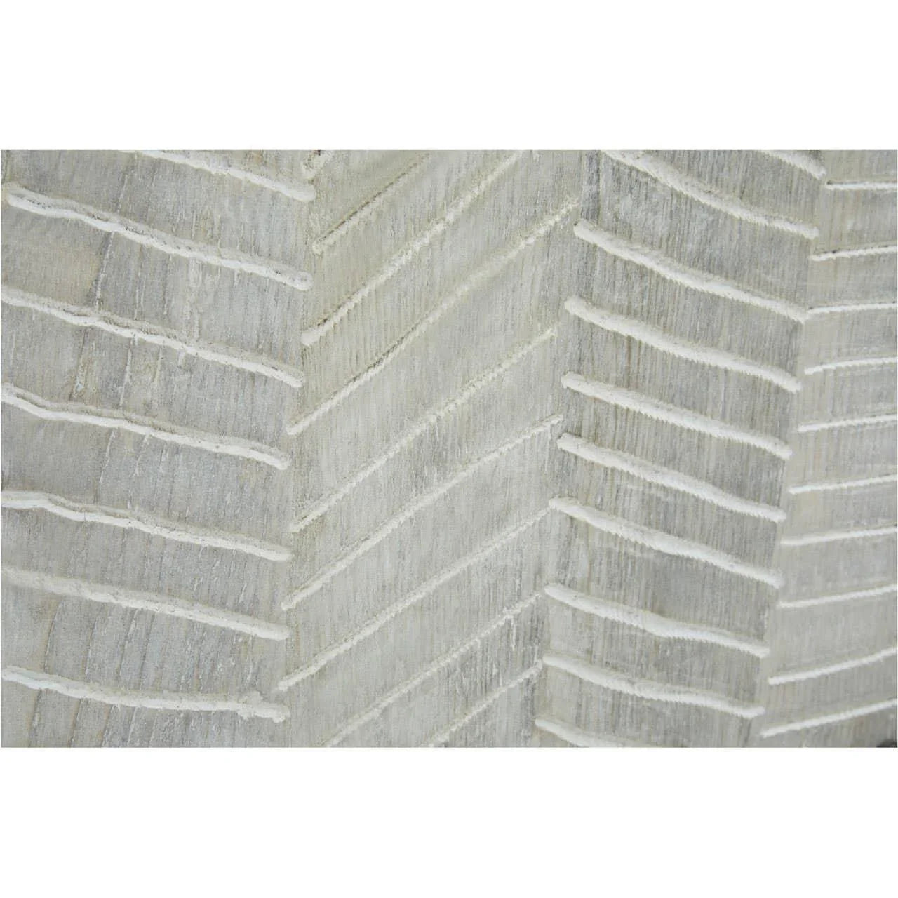 Close-up of textured wood furniture panel with white chevron carved pattern