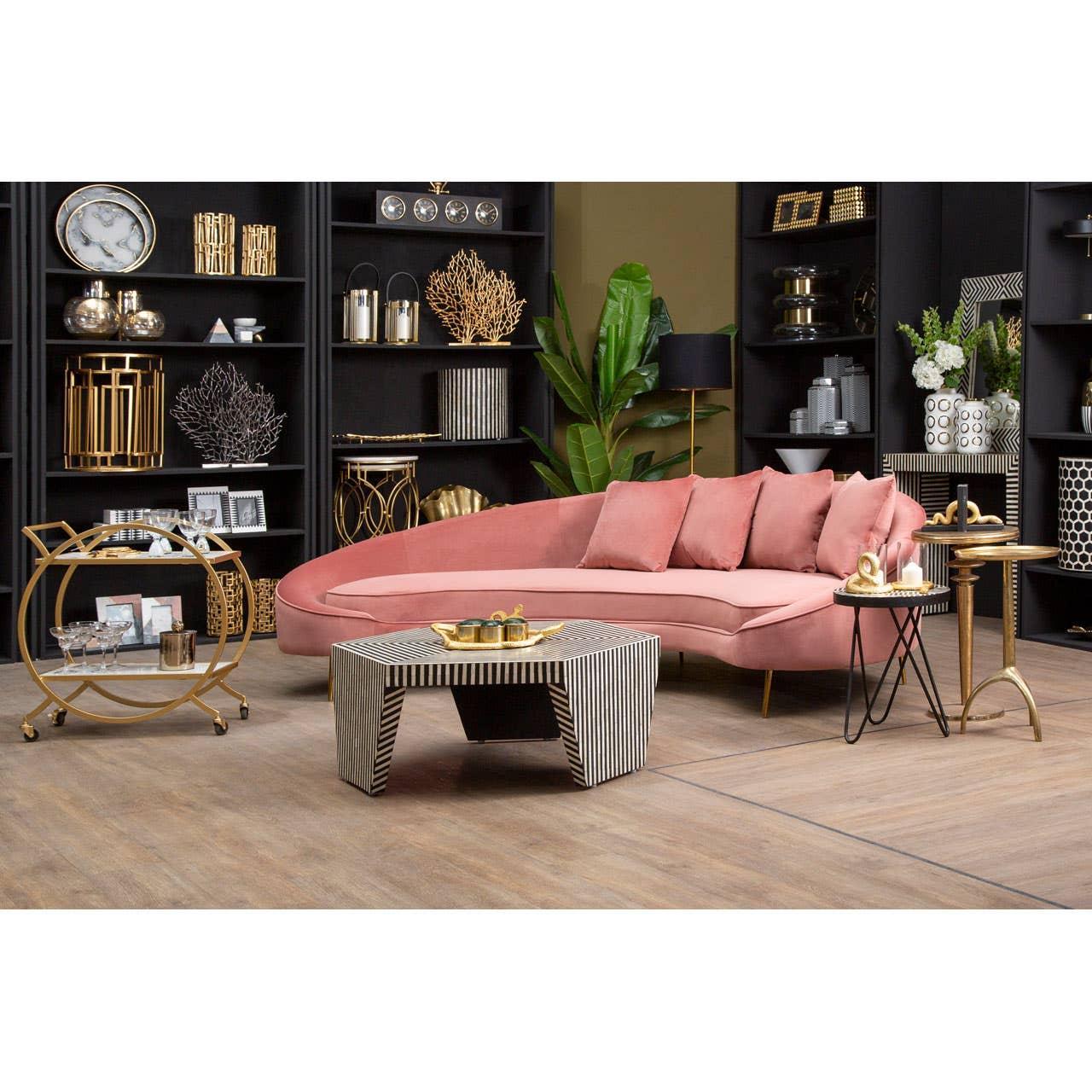 Pink velvet corner sofa with matching cushions in modern living room, gold decor accents