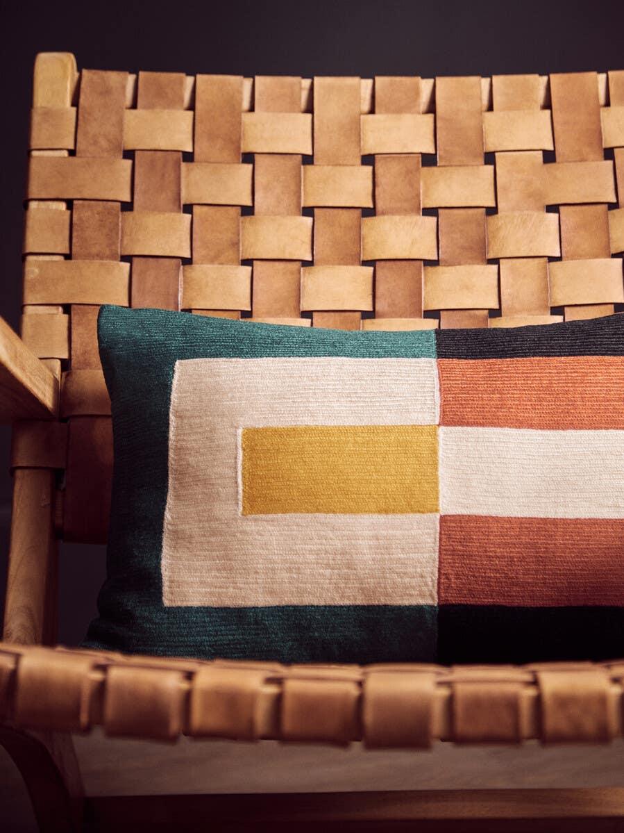 Tan woven leather accent chair with geometric patterned cushion