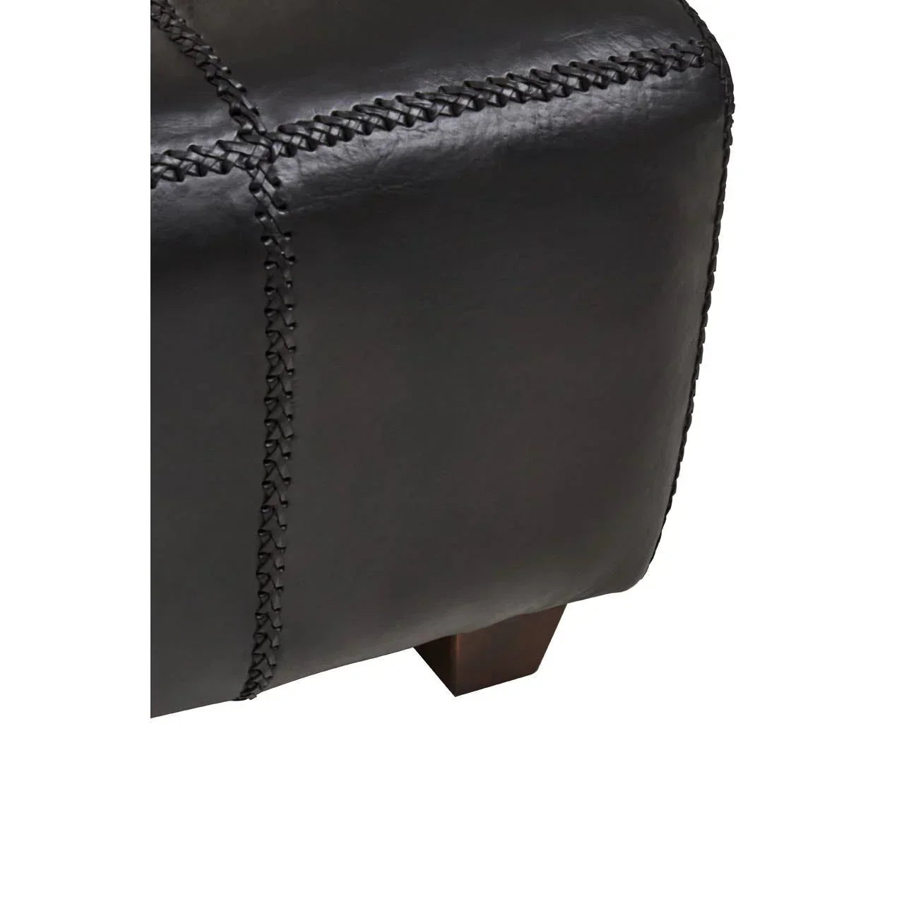 Close-up of black leather ottoman with stitched detail and wooden leg