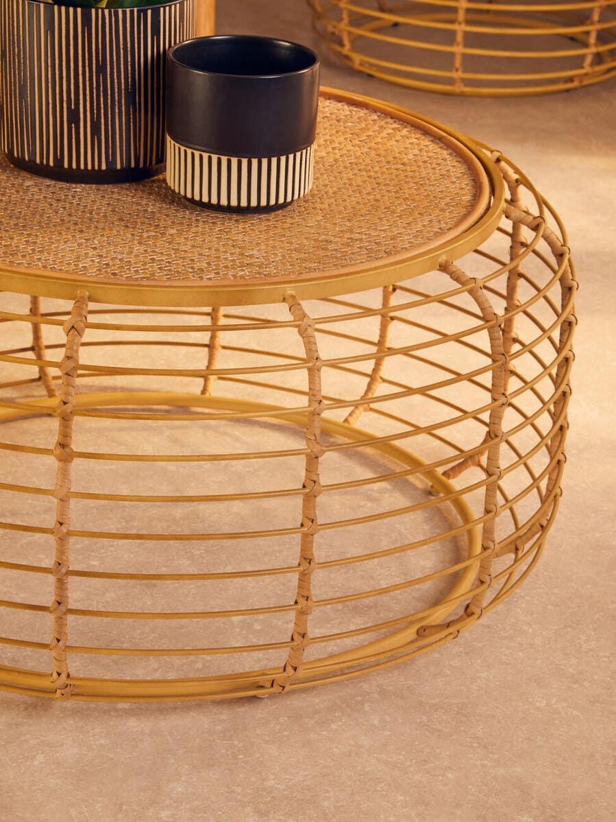 Round rattan coffee table with woven top and decorative black ceramic vases