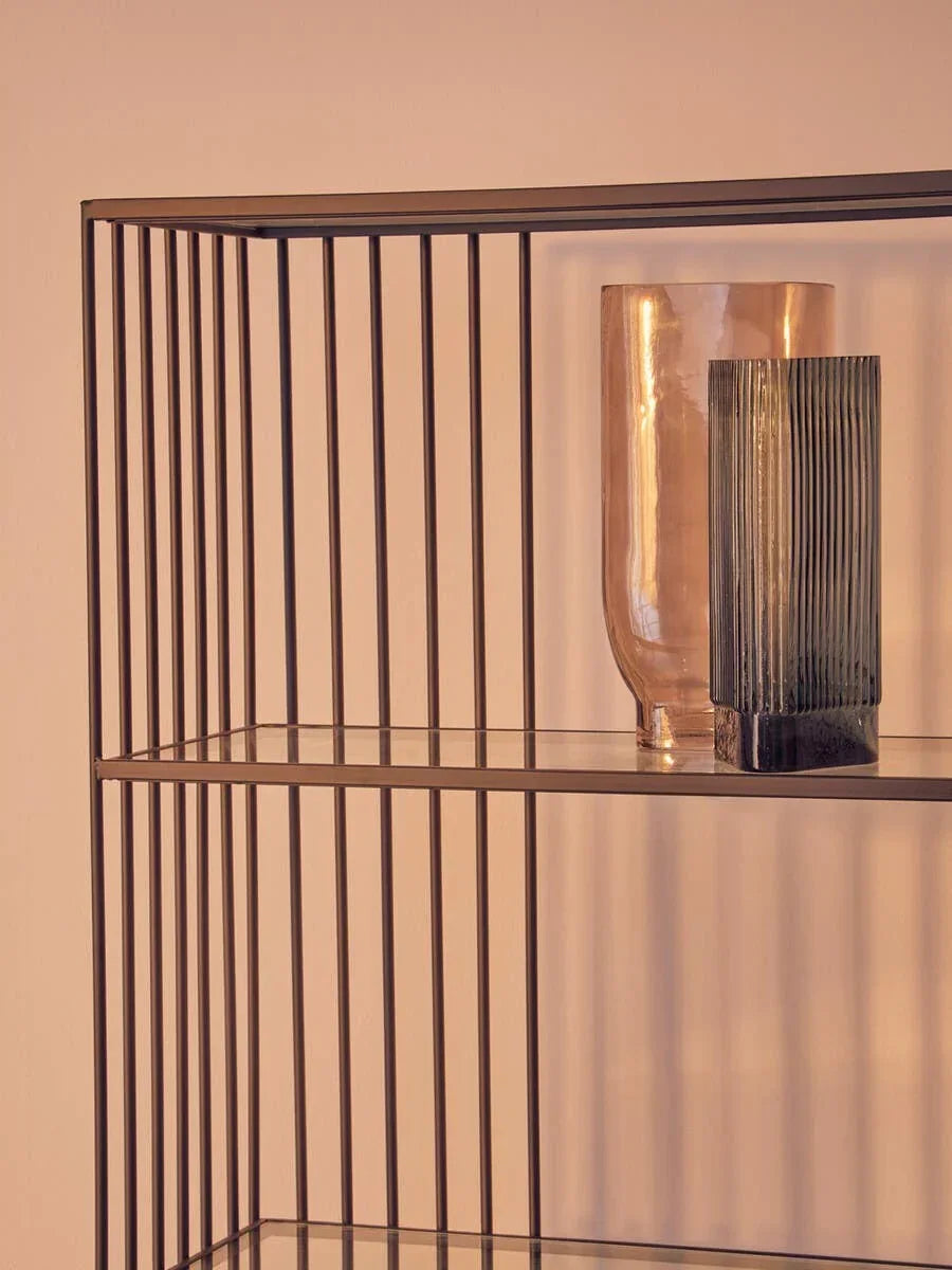 Black metal shelving unit with glass shelf and decorative vases