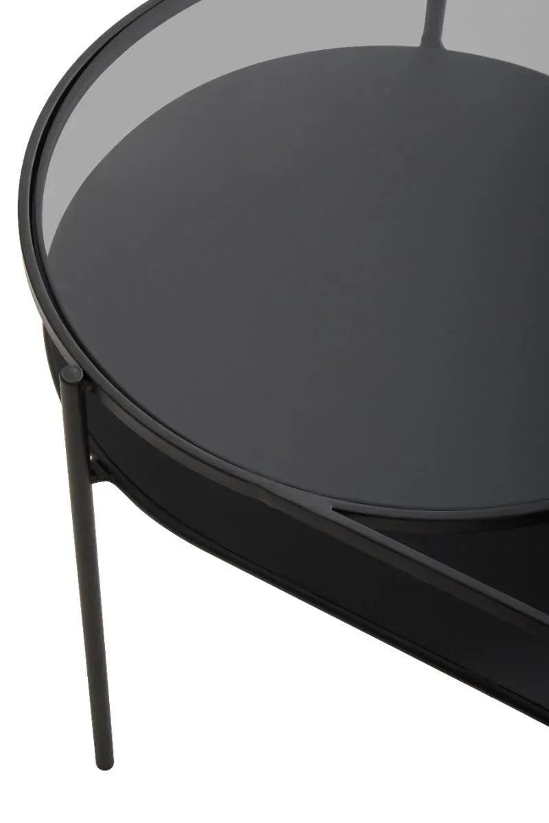 Round black glass coffee table with metal frame, close-up of tabletop and legs