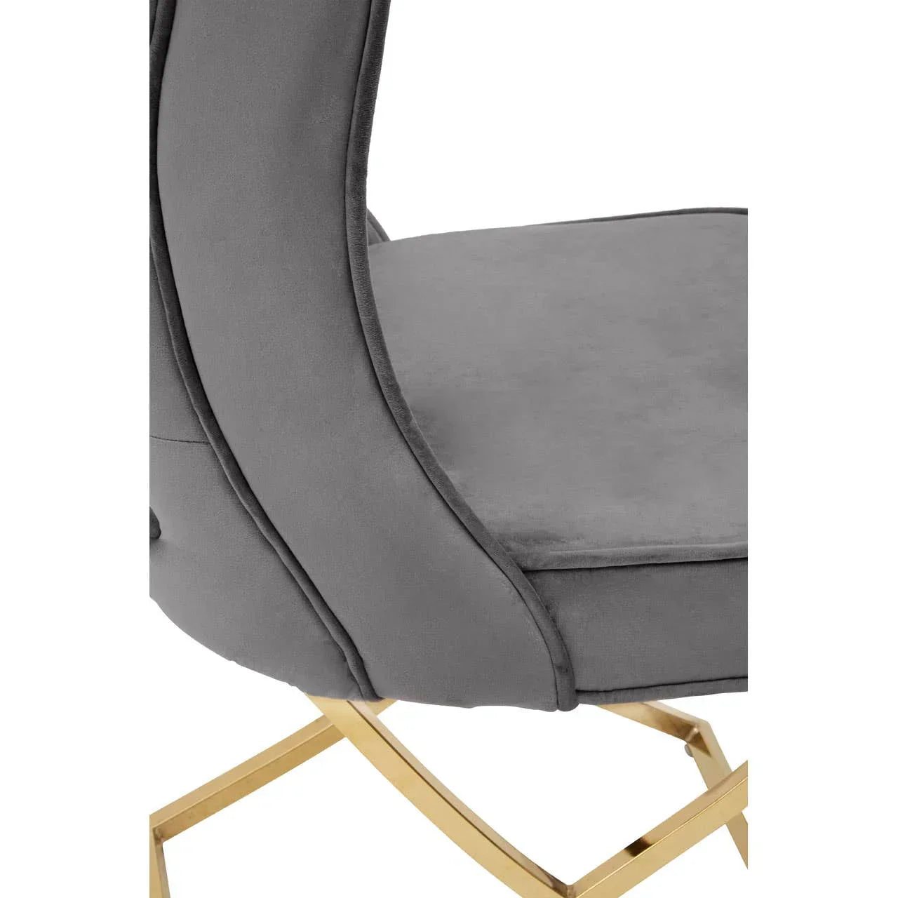 Closeup of grey velvet dining chair with gold metal legs