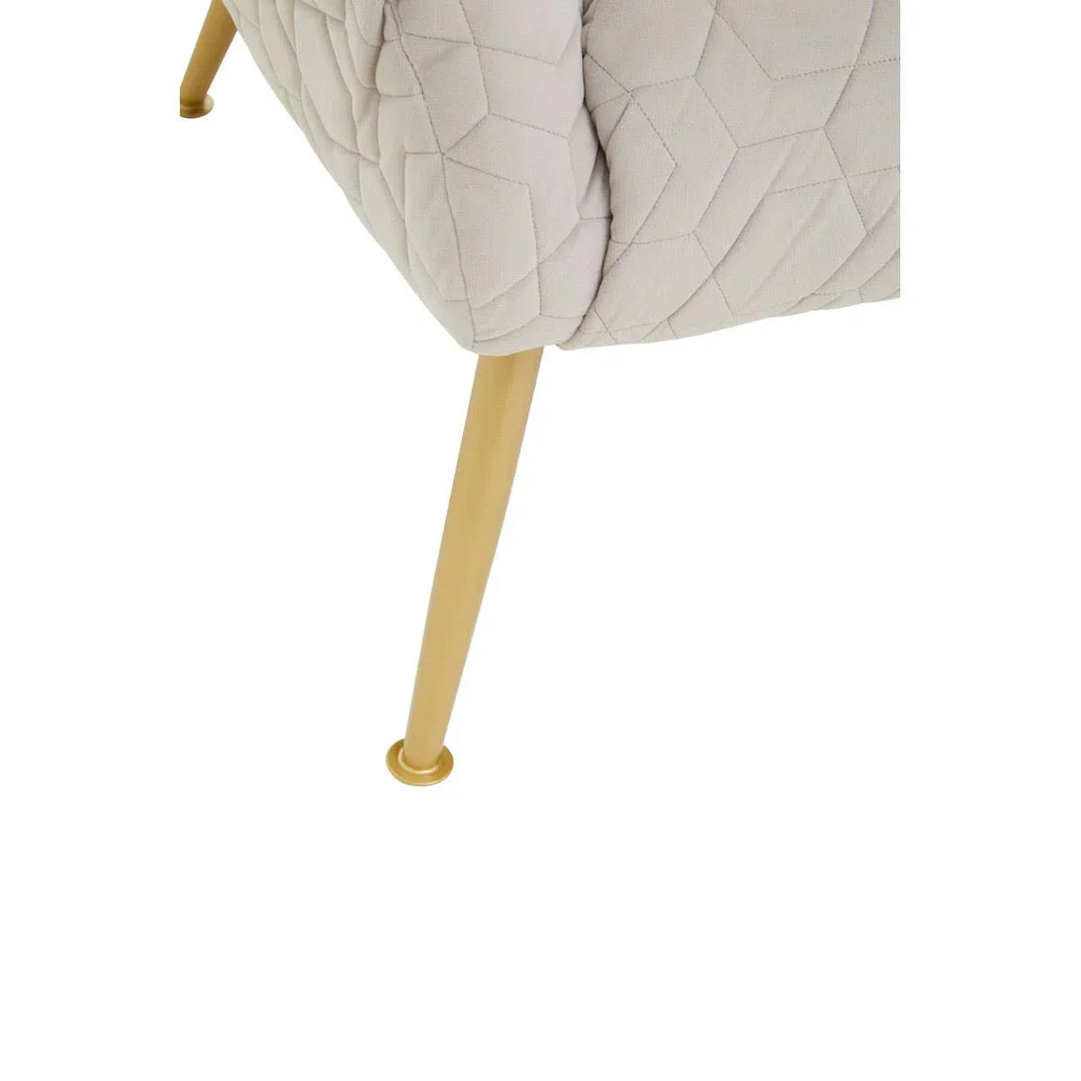 Upholstered chair with quilted beige fabric and gold metal tapered leg, close-up view