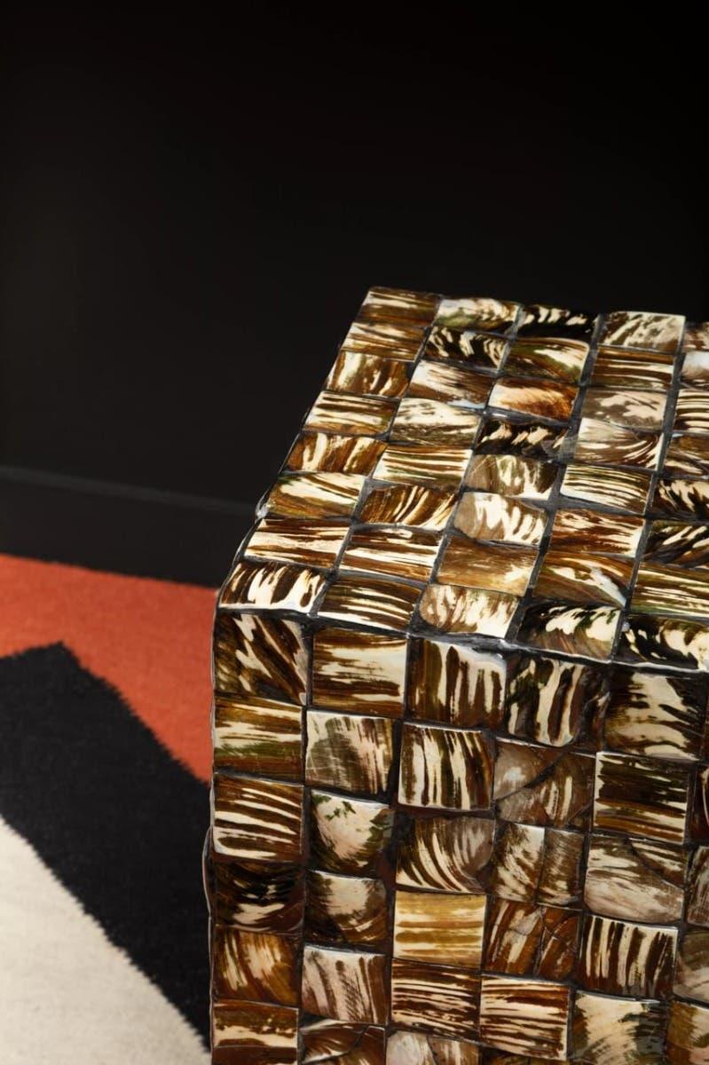 Brown mosaic side table with square patterned surface in modern living room setting