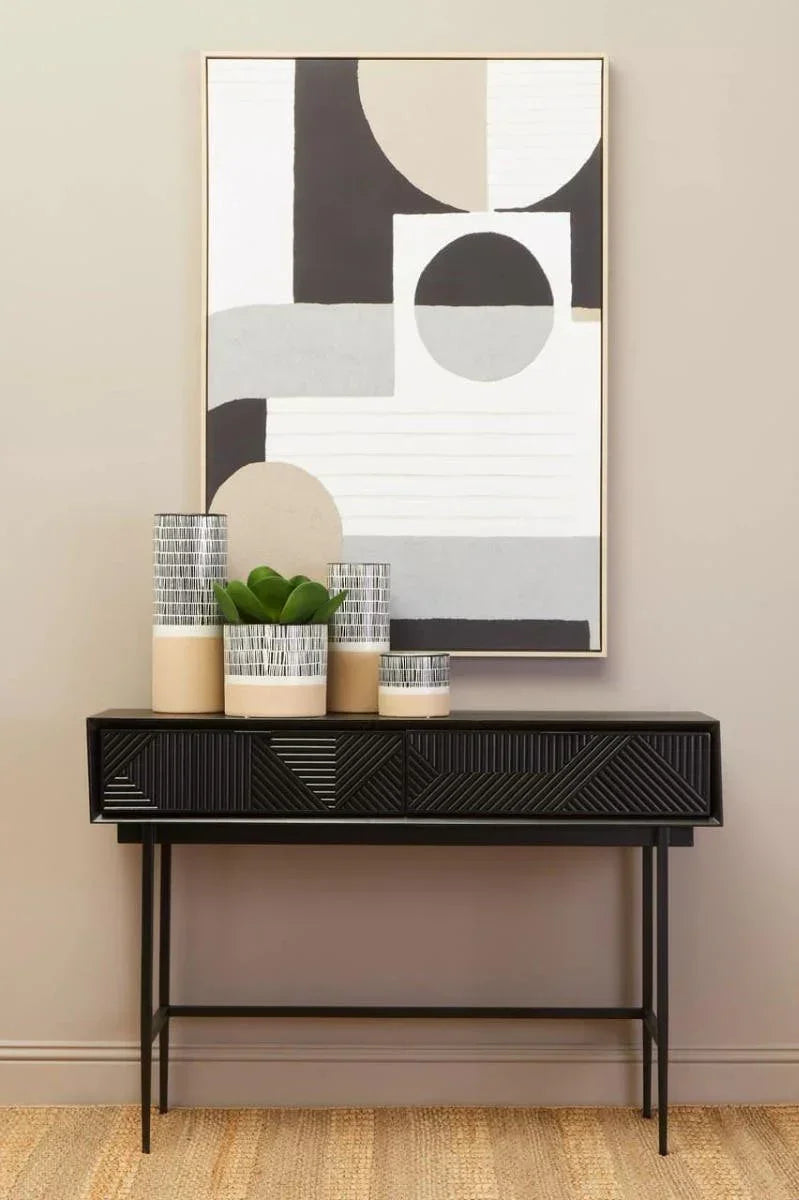Black console table with textured drawers, ceramic vases and modern abstract wall art