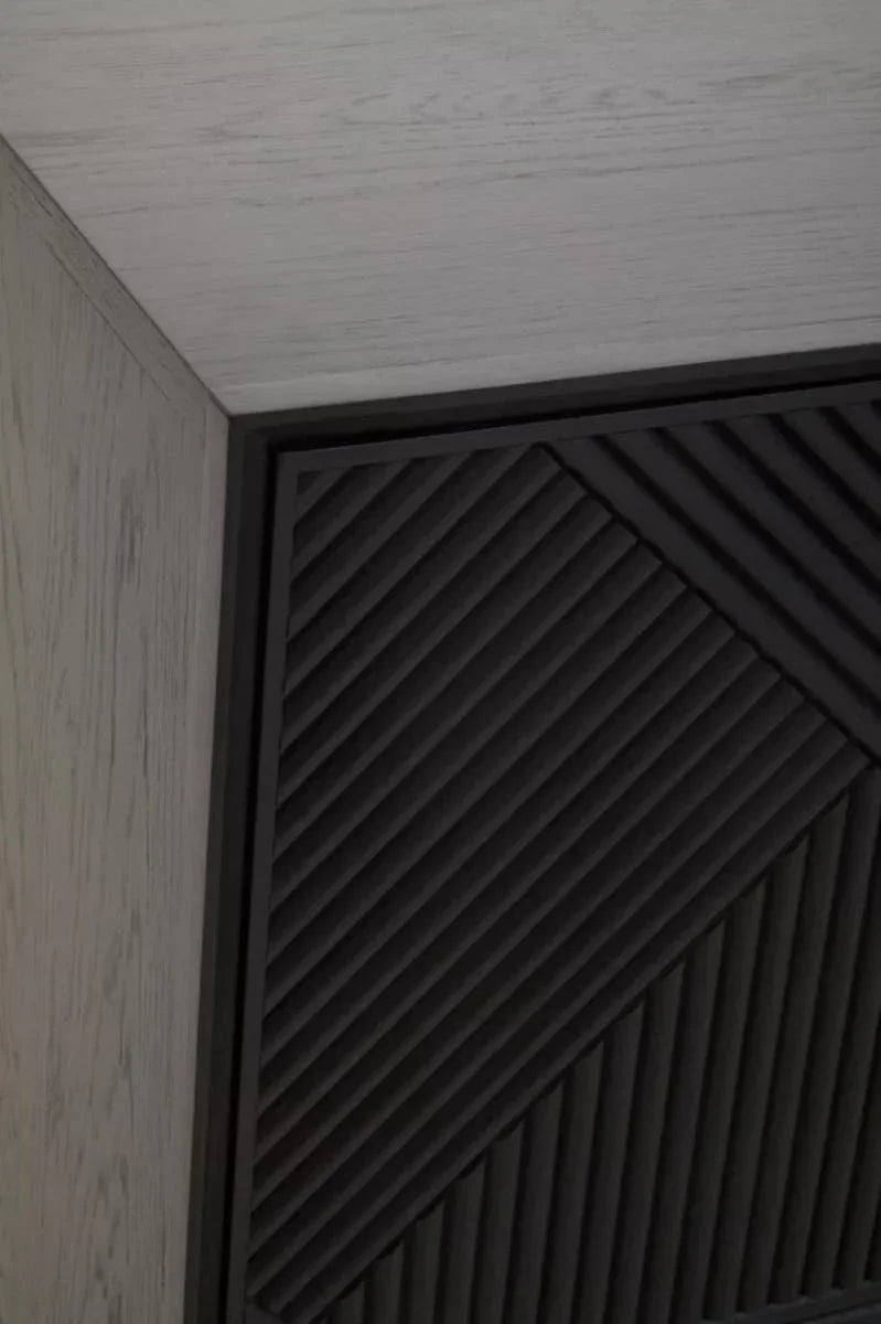 Close up of wooden cabinet corner with black geometric panel detail