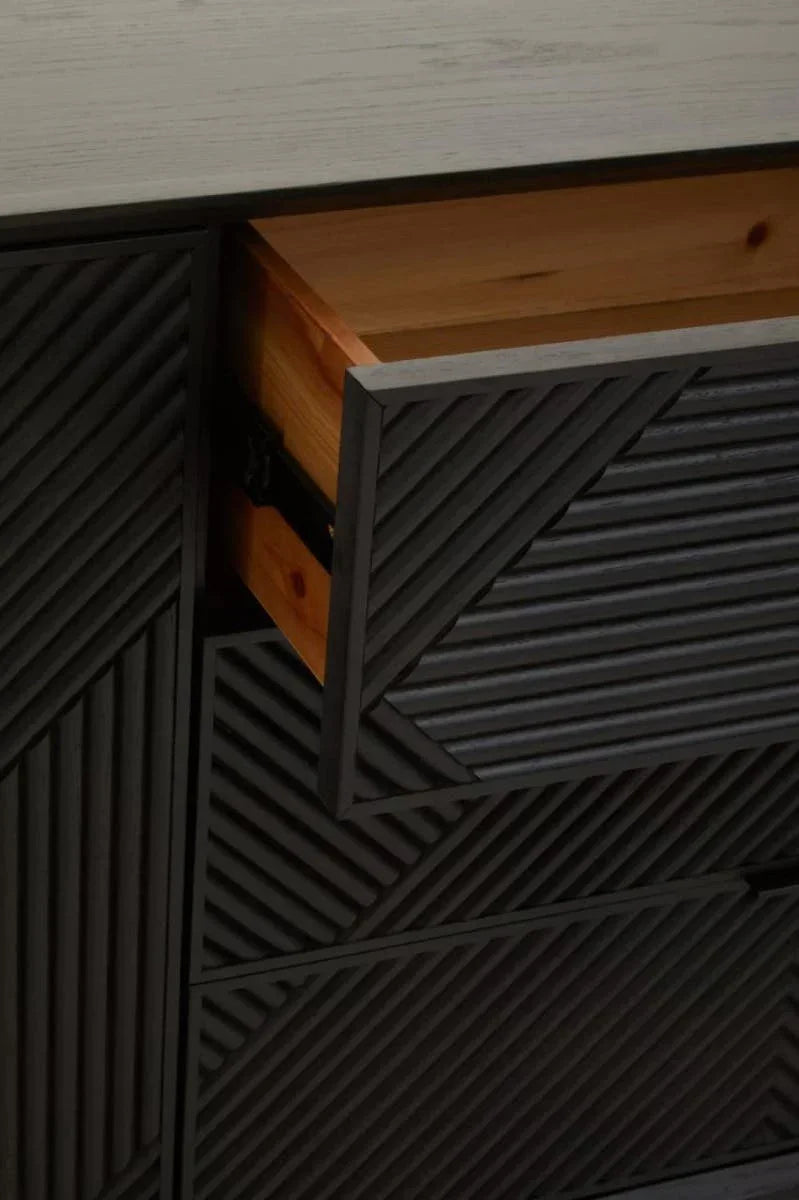 Textured black wood chest of drawers with geometric pattern, close-up of open drawer