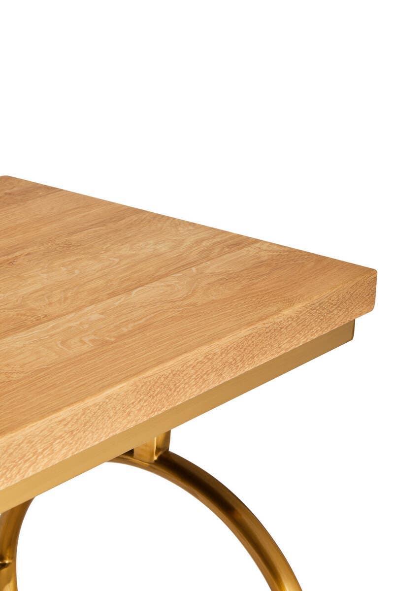 Oak wood dining table with gold metal frame, close-up of tabletop and leg detail