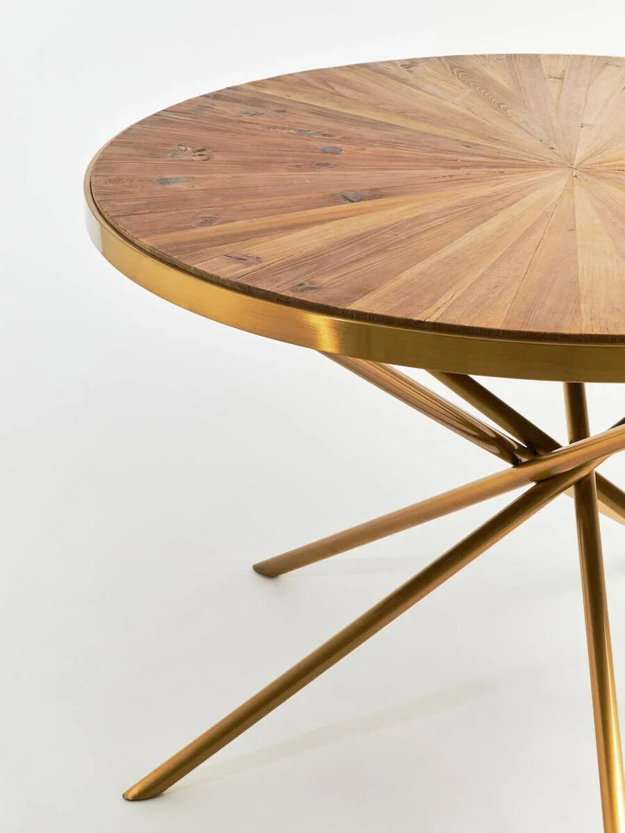 Round wooden dining table with gold metal legs and sunburst patterned top