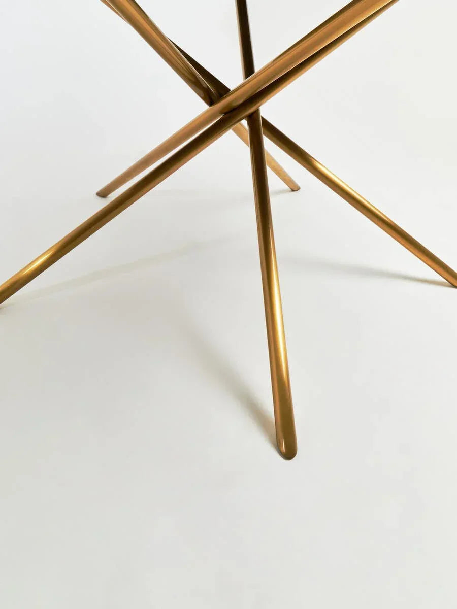 Gold metal table legs in modern crossed design on white background
