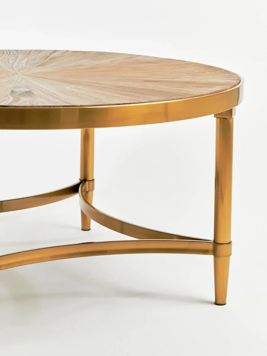 Round coffee table with gold metal legs and light wood top close-up