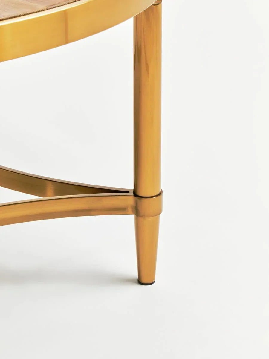 Gold metal furniture leg with curved wood support on white background