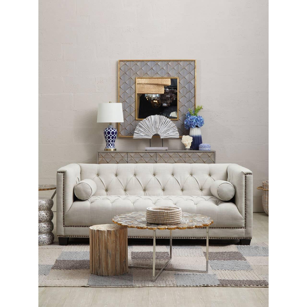 Neutral button-tufted sofa with round cushions, coffee table and console in modern living room