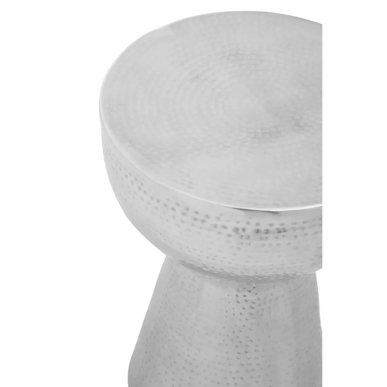 Close-up of silver hammered metal side table with round top and textured surface
