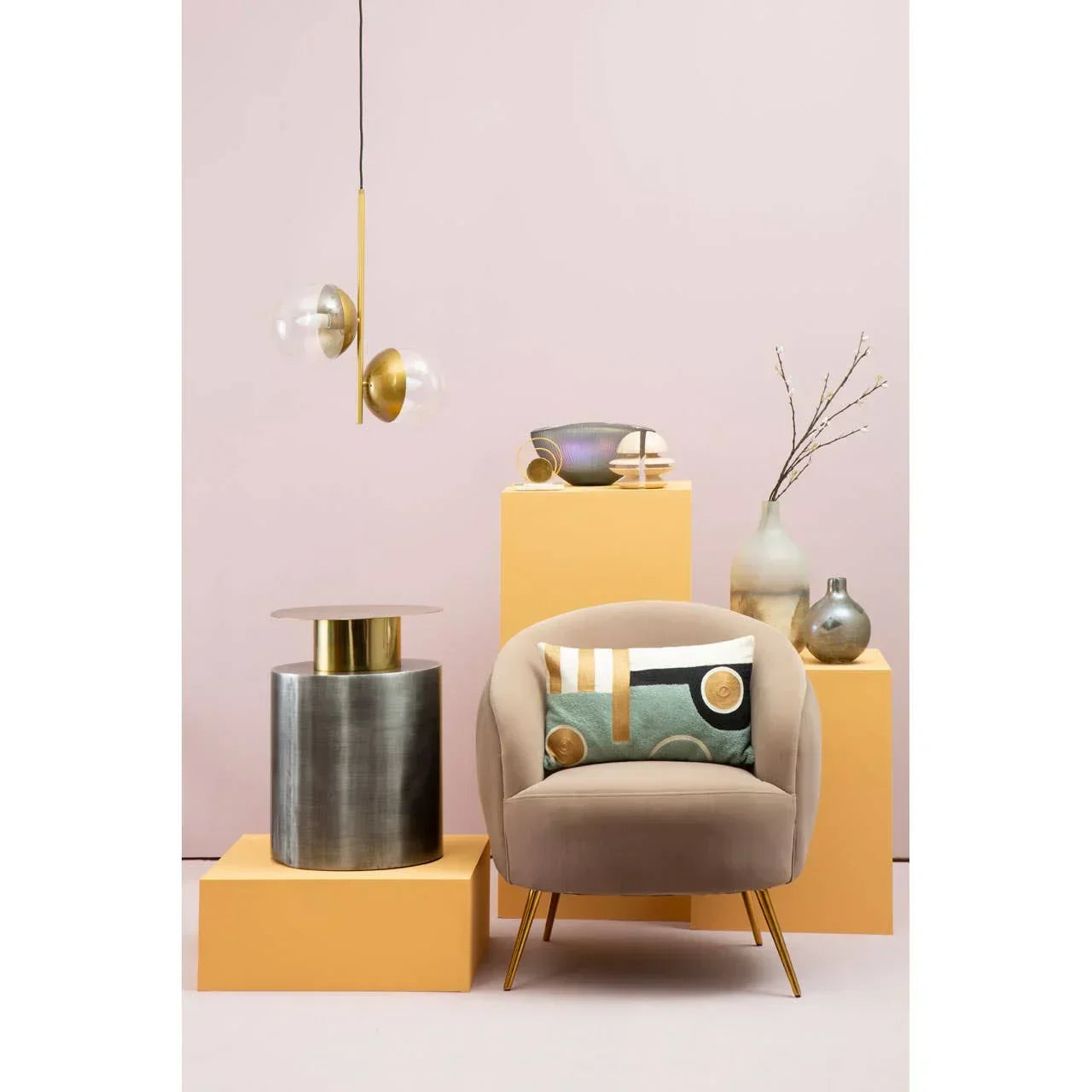 Modern beige armchair with geometric cushion, metallic side table, and gold pendant light