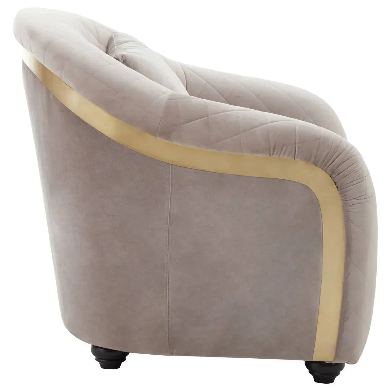 Side view of grey velvet armchair with quilted backrest and gold accent trim