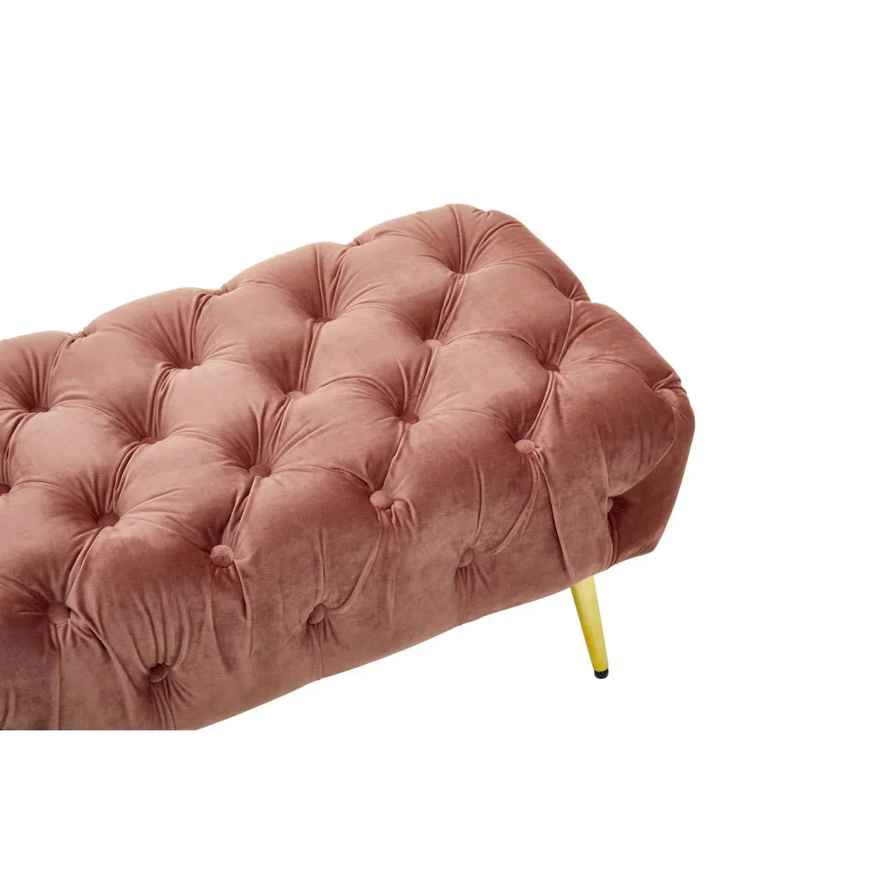 Blush pink velvet ottoman with button-tufted upholstery and gold metal legs, angled view