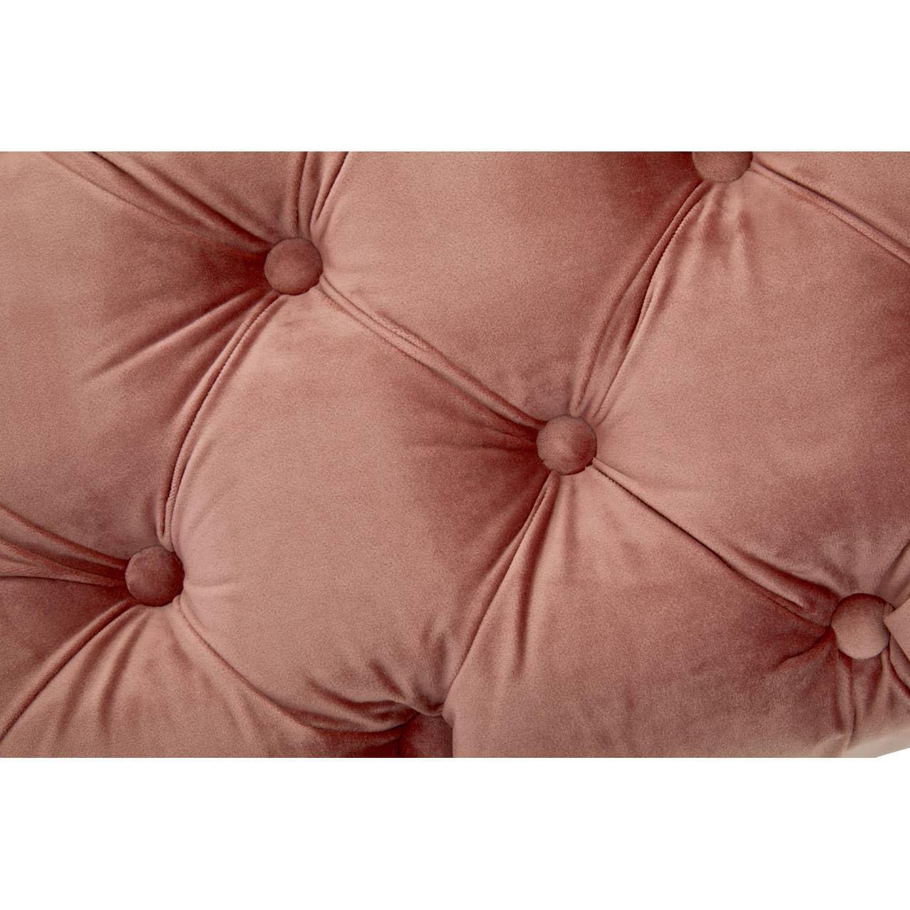 Closeup of pink velvet upholstered sofa with deep button tufting