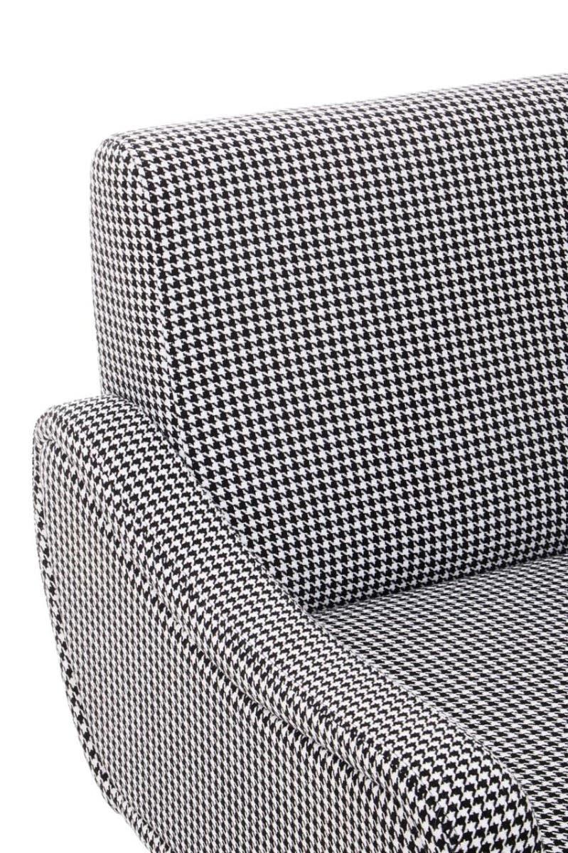 Houndstooth fabric armchair closeup showing curved armrest and backrest detail