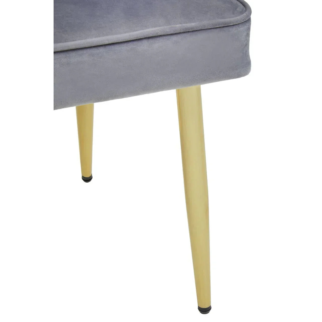 Grey velvet dining chair with light wood tapered legs, close-up corner view