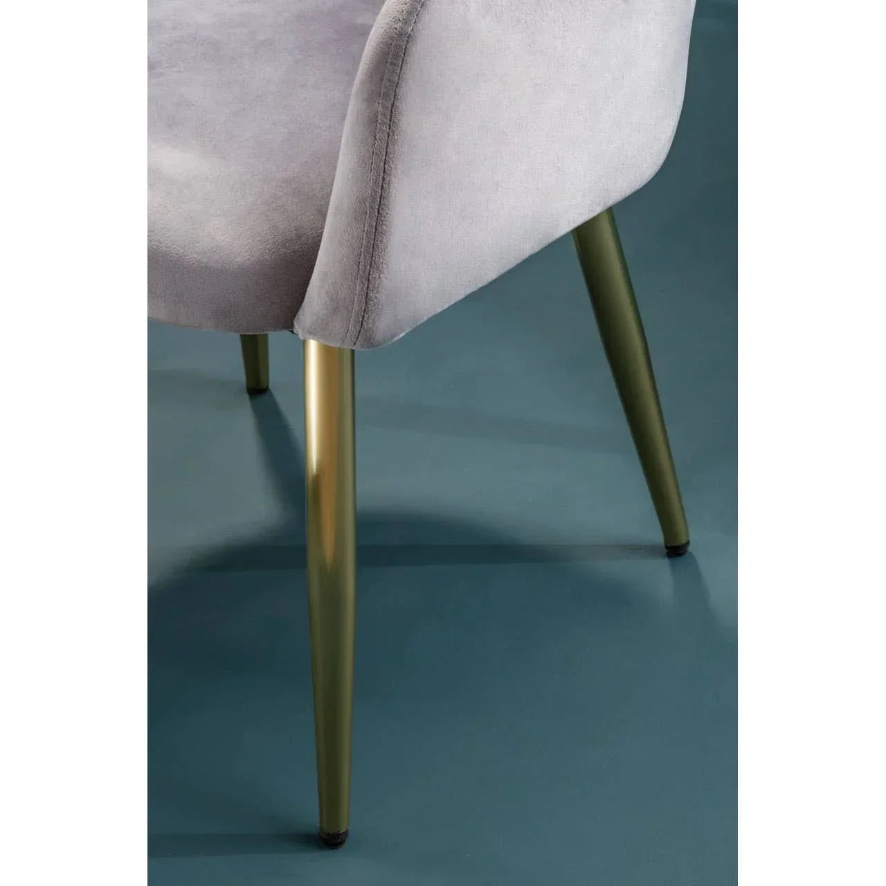 Grey velvet dining chair with gold metal legs closeup