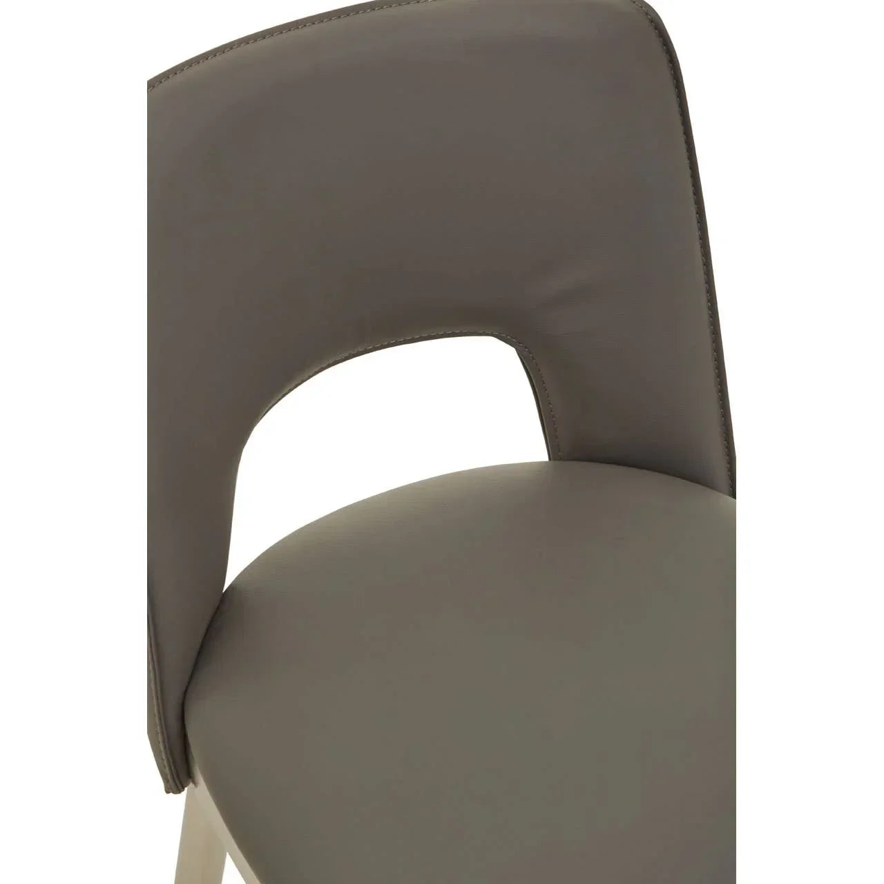Close view of taupe faux leather dining chair with curved backrest and cut-out detail