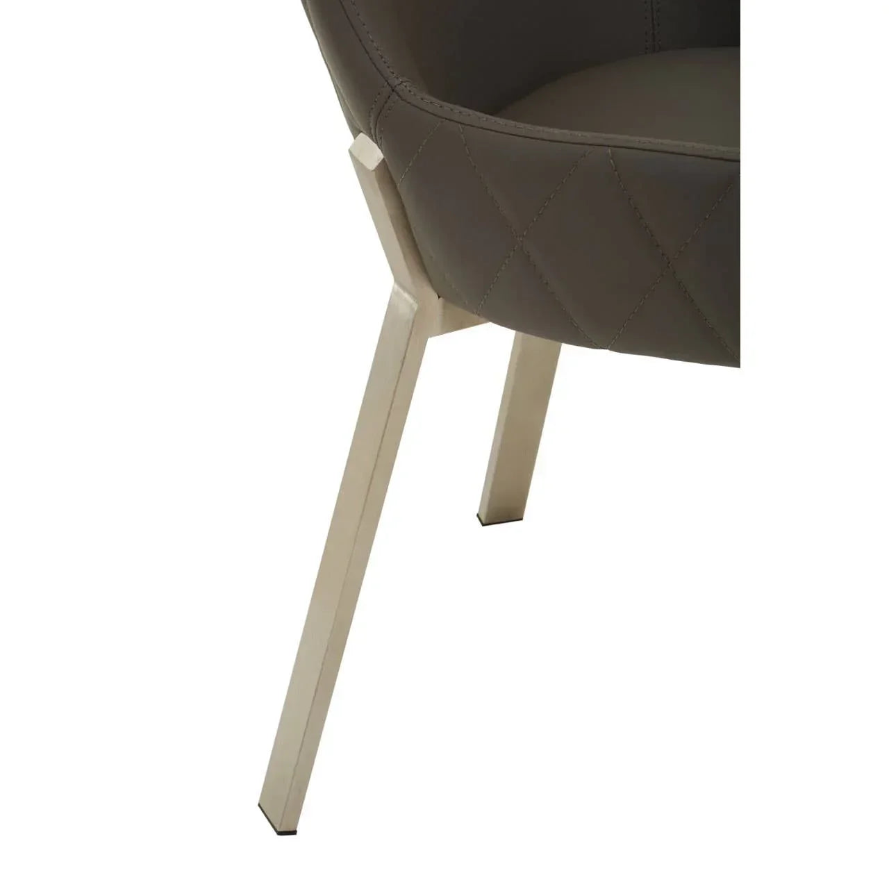 Detail of upholstered dining chair with quilted stitching and angled metal legs