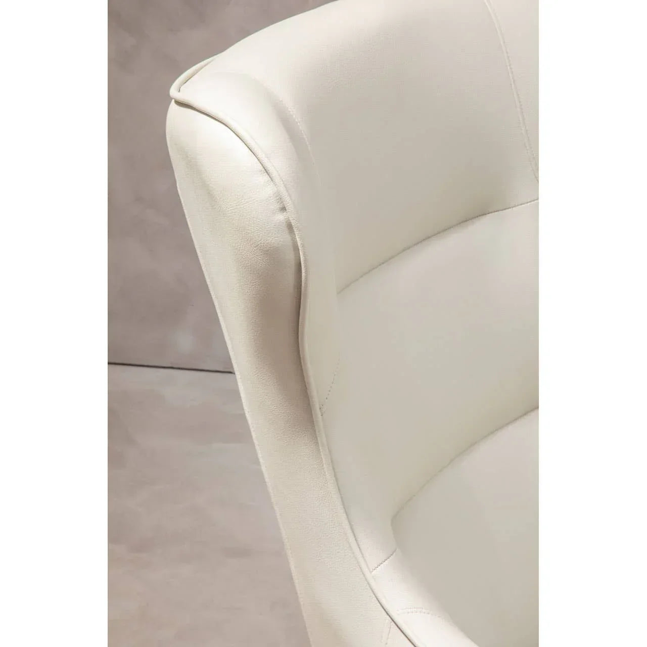 Closeup of cream leather armchair backrest with soft upholstery detail