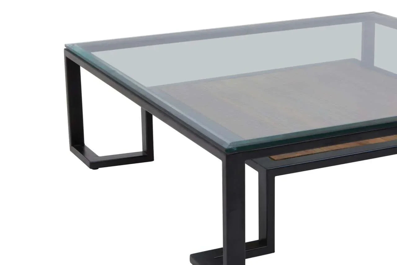 Glass top coffee table with black metal frame and wooden lower shelf, side angle view