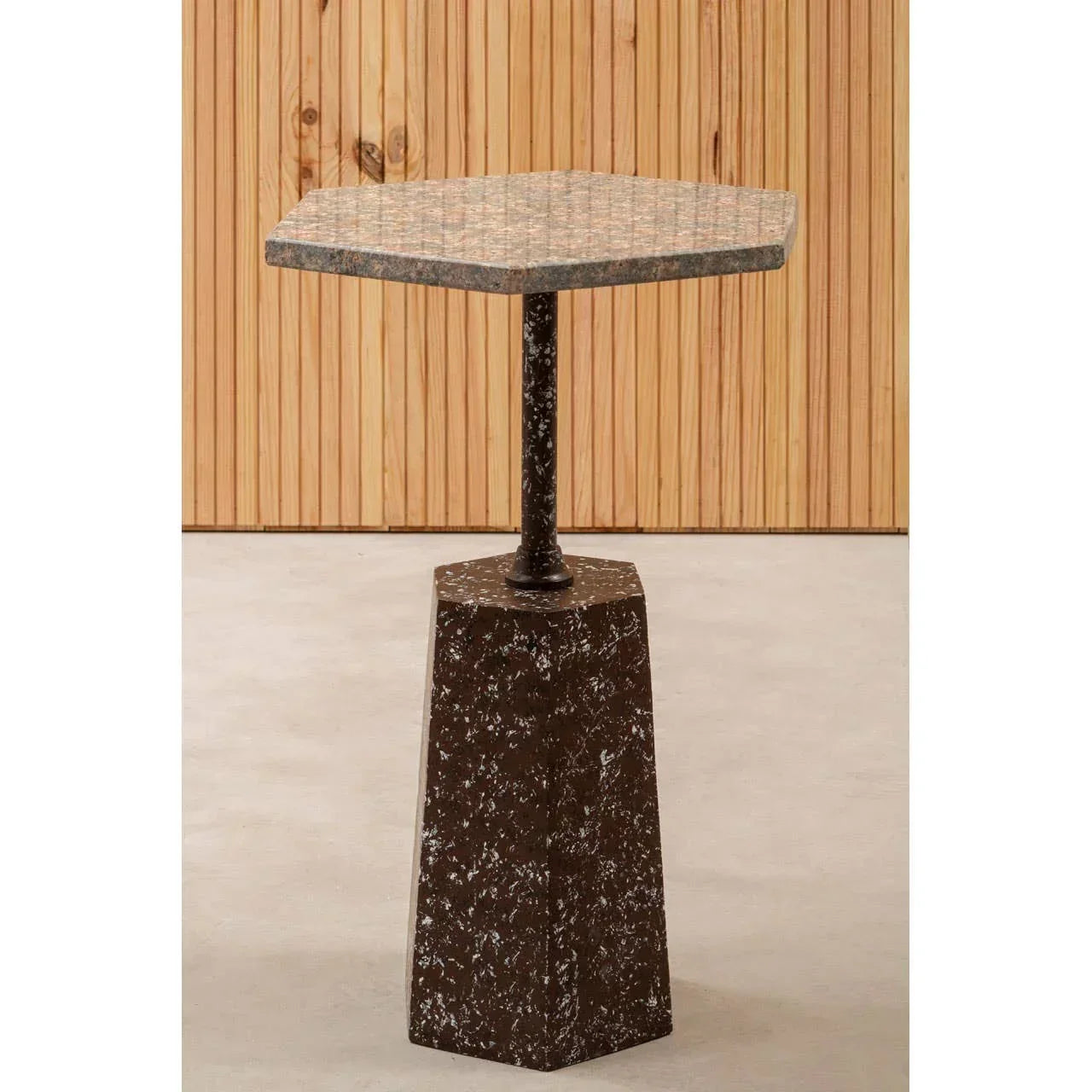Hexagonal marble side table with brown speckled base and metal support, indoor setting