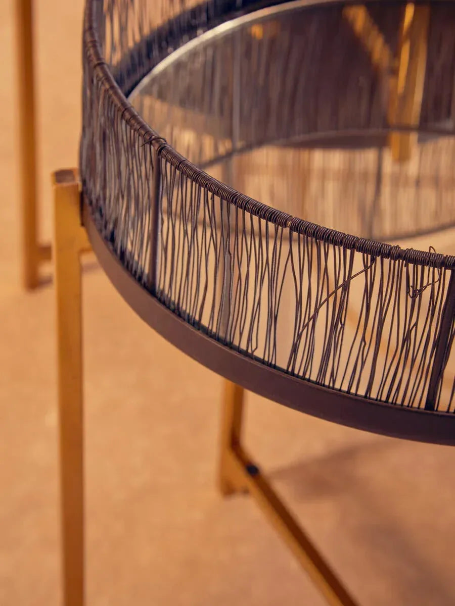 Round glass top side table with metal wire detail and gold legs