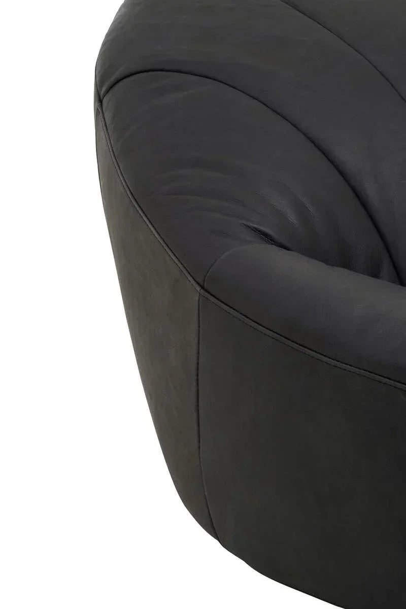 Close-up of black leather sofa corner with curved stitching detail