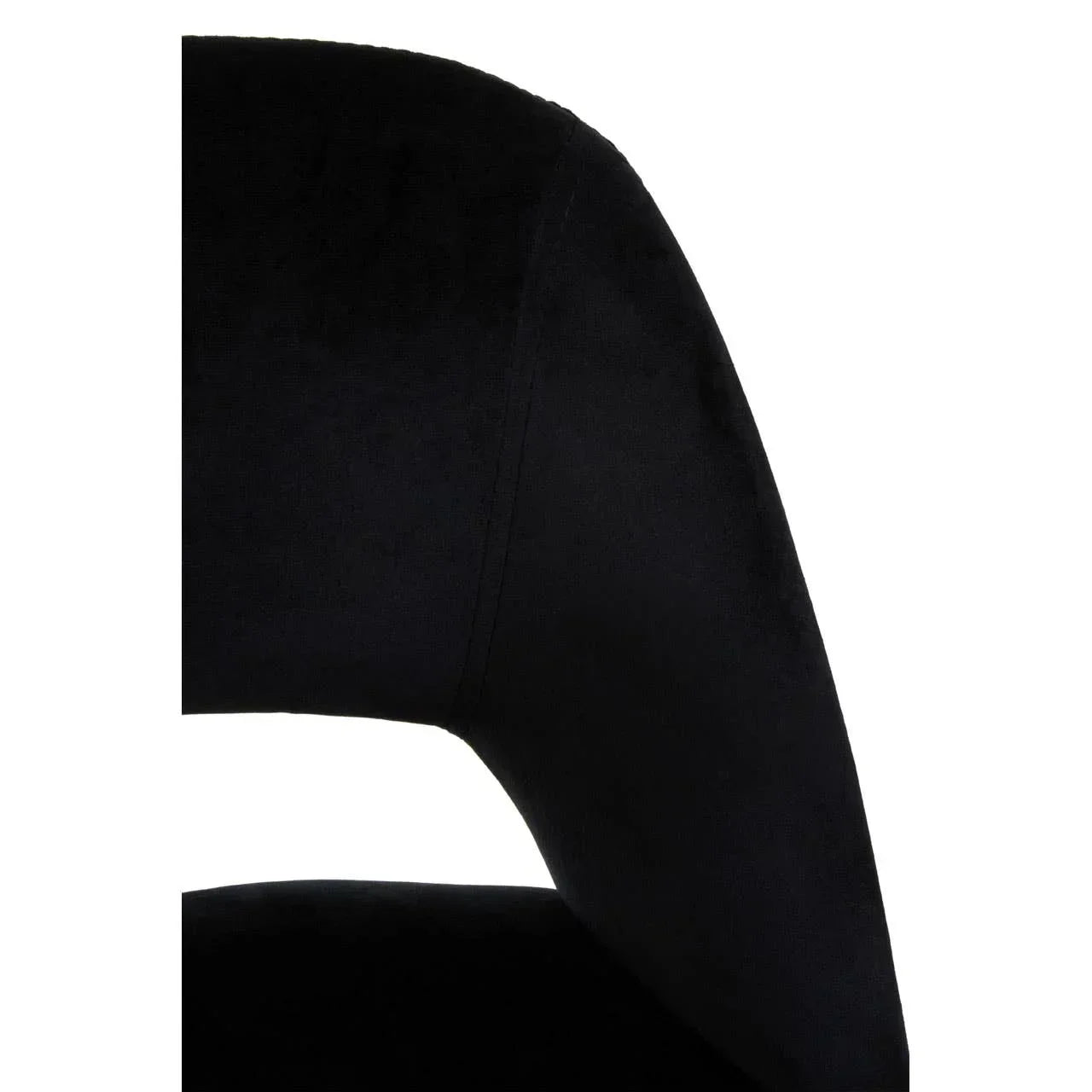 Close-up of black velvet dining chair curved backrest and seat detail