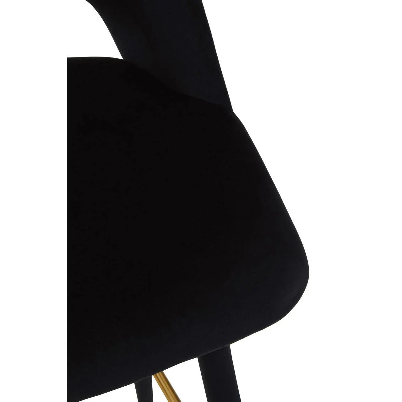 Close-up of black velvet dining chair seat with gold leg accent