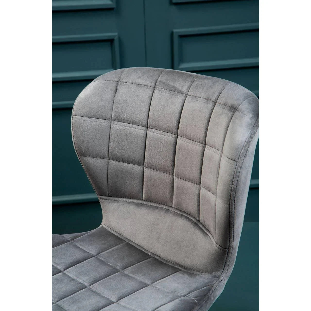 Grey velvet dining chair with stitched grid pattern, close-up of cushioned backrest