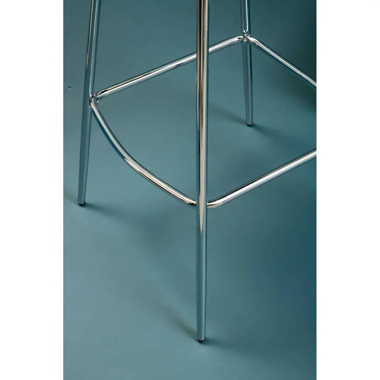 chrome bar stool legs with footrest detail on teal floor